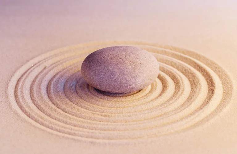 runder kieselstein in zen-garten sandkreisen