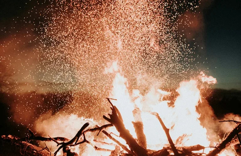 Funken steigen aus einem Feuer in den Abendhimmel – Räucherritual und Jahresabschluss mit Simone