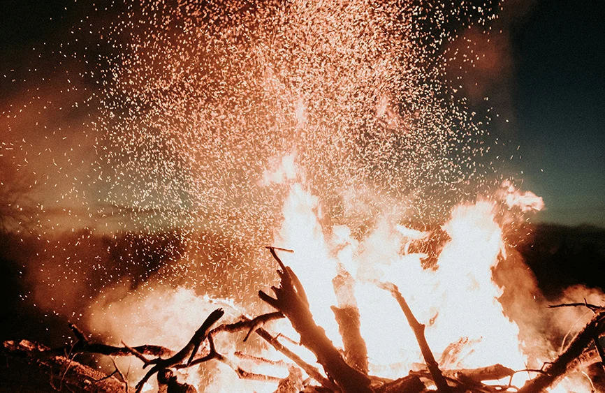 Funken steigen aus einem Feuer in den Abendhimmel – Räucherritual und Jahresabschluss mit Simone